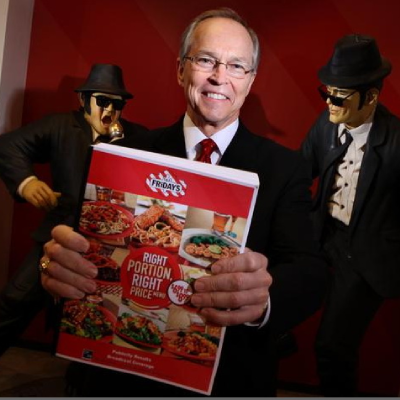 A man holding a menu in front of statues.