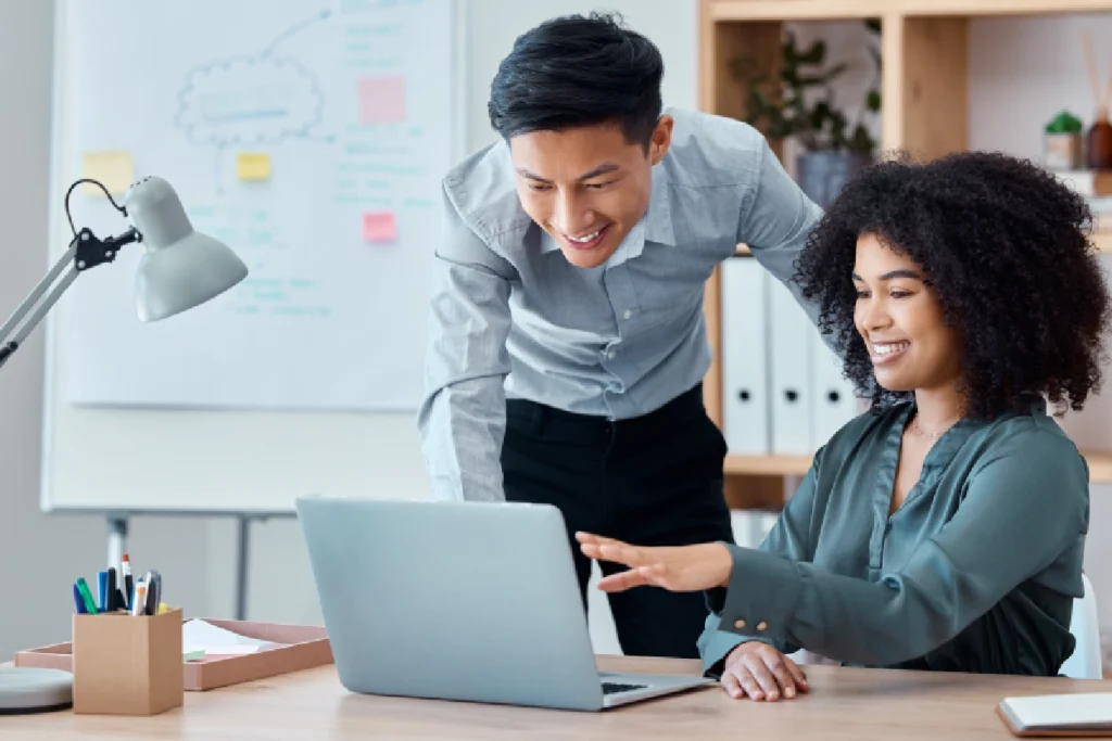 A man and woman looking at a laptop