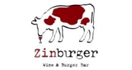 A cow drinking wine from a glass on the side of a bar.