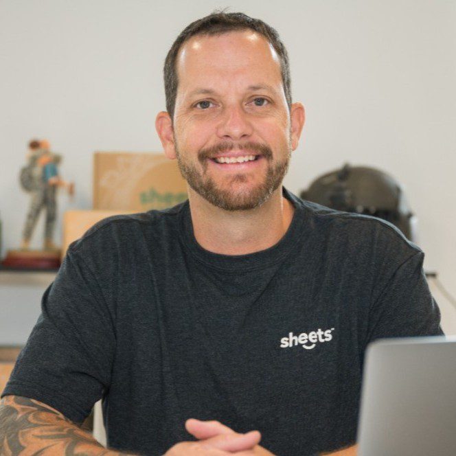 A man sitting at a table with a laptop.