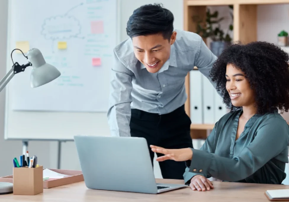 A man and woman looking at a laptop